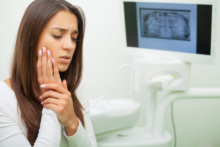 Young Female Having Toothache. Upset Woman At The Dentist. Constant Pulsating Pain emergency dentist East Melbourne